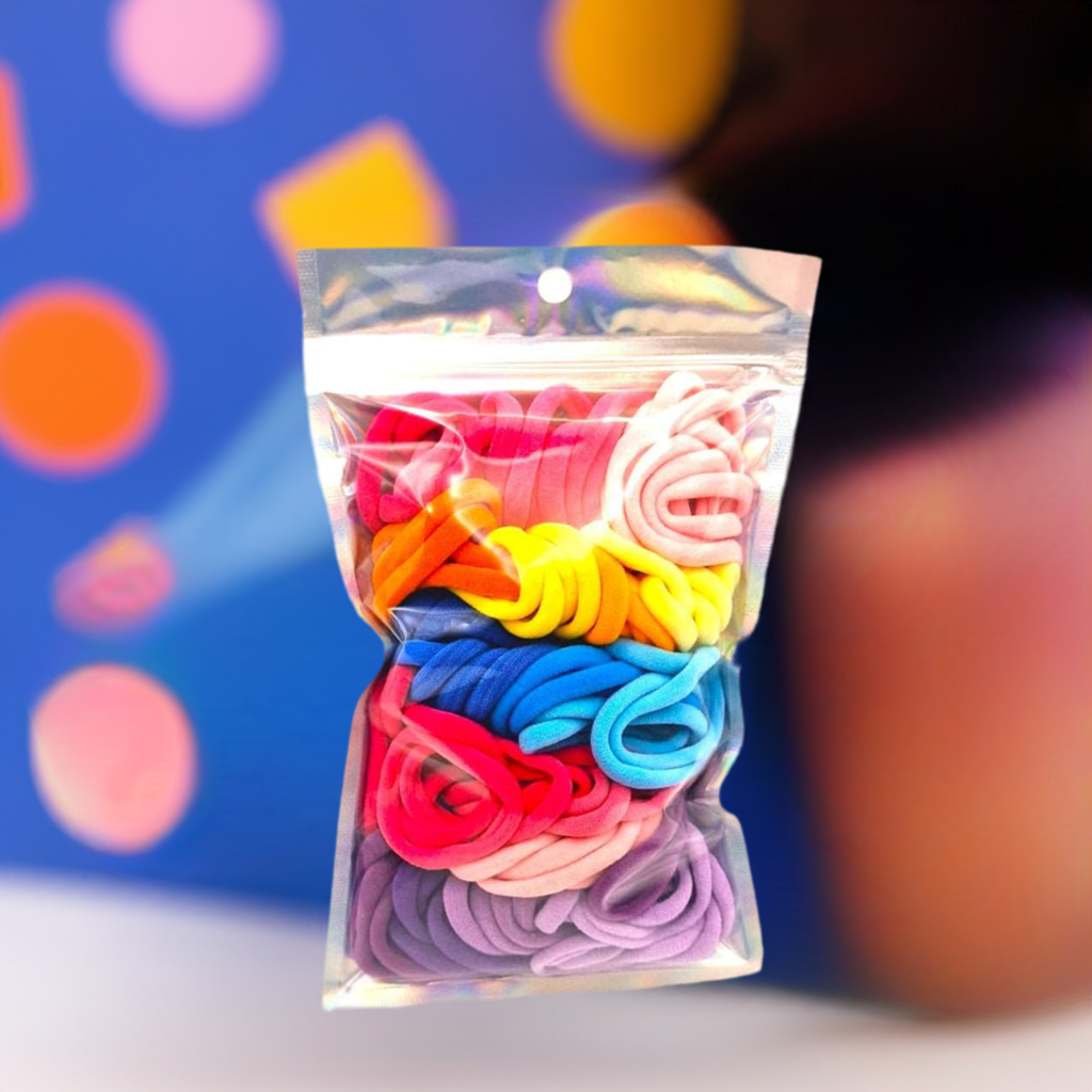 Girl's Hair Ties: ENAX Multi-Coloured Hair Bands, One silver pack of (ENAX) colorful medium-sized Hair Ties. 80 hair ties inside each pack. Colourful blurry background. Front Side.