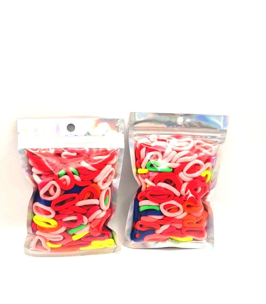 Baby & Toddler's Hair Ties Pack of 2: ENAX Hair Bands, Two silver packet of (ENAX) colorful small sized Hair Ties. Mostly light and dark Pink coloured Hair Ties. 120 hair ties inside each pack, two packets in picture. Transparent Front side.