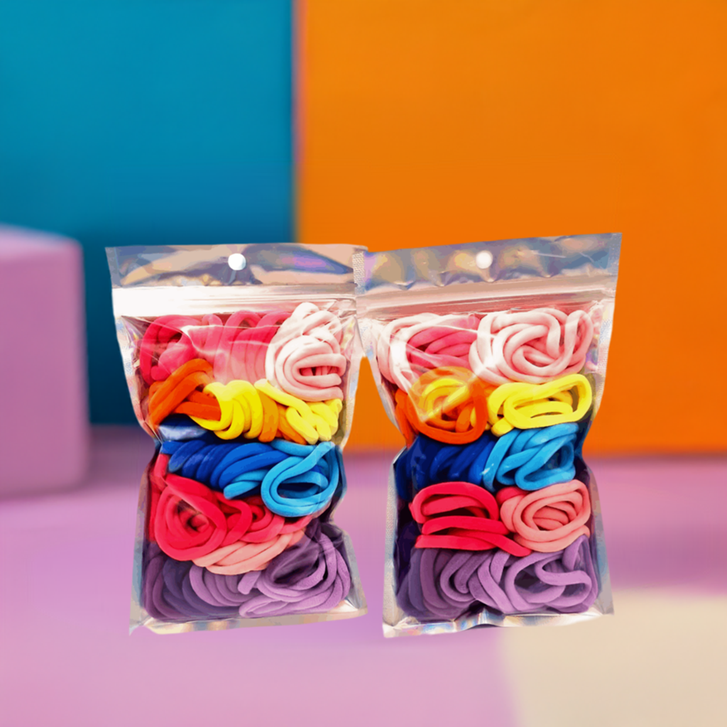 Girls' Hair Ties Pack of 2: ENAX Multi-Coloured Girls Hair Bands, Two silver packet of (ENAX) colorful medium-sized Hair Ties. 80 hair ties inside each pack, two packets in picture. Blue and Orange colour block background. Front Side.